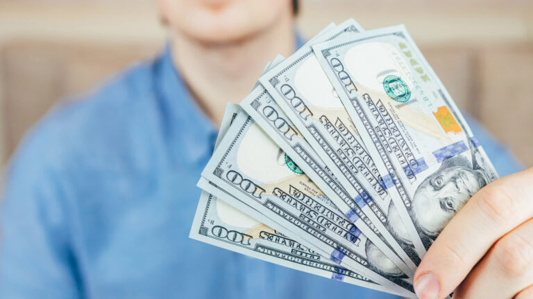Man holding US dollars in his hand.