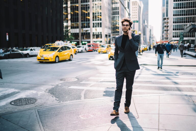 Entrepreneur visiting the US, walking in New York City with taxis in the background.